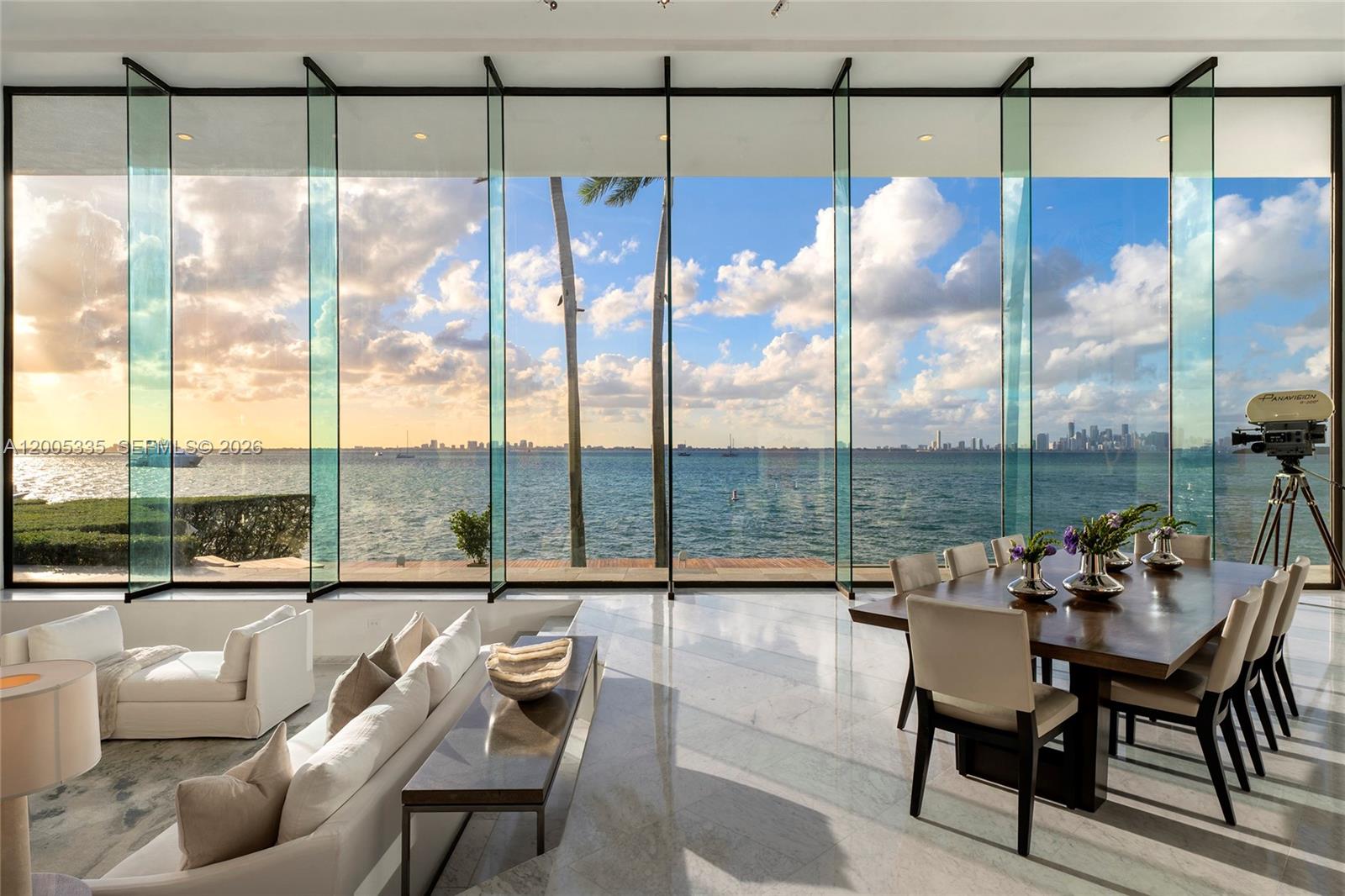 A dining and living area features floor-to-ceiling glass walls overlooking the ocean and city skyline — 485 W Matheson Dr, Key Biscayne FL 33149, KEY BISCAYNE, FL