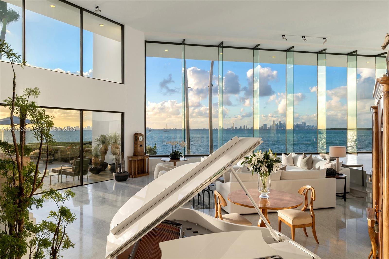 A bright living room features a white grand piano, floor-to-ceiling windows, and ocean views — 485 W Matheson Dr, Key Biscayne FL 33149, KEY BISCAYNE, FL
