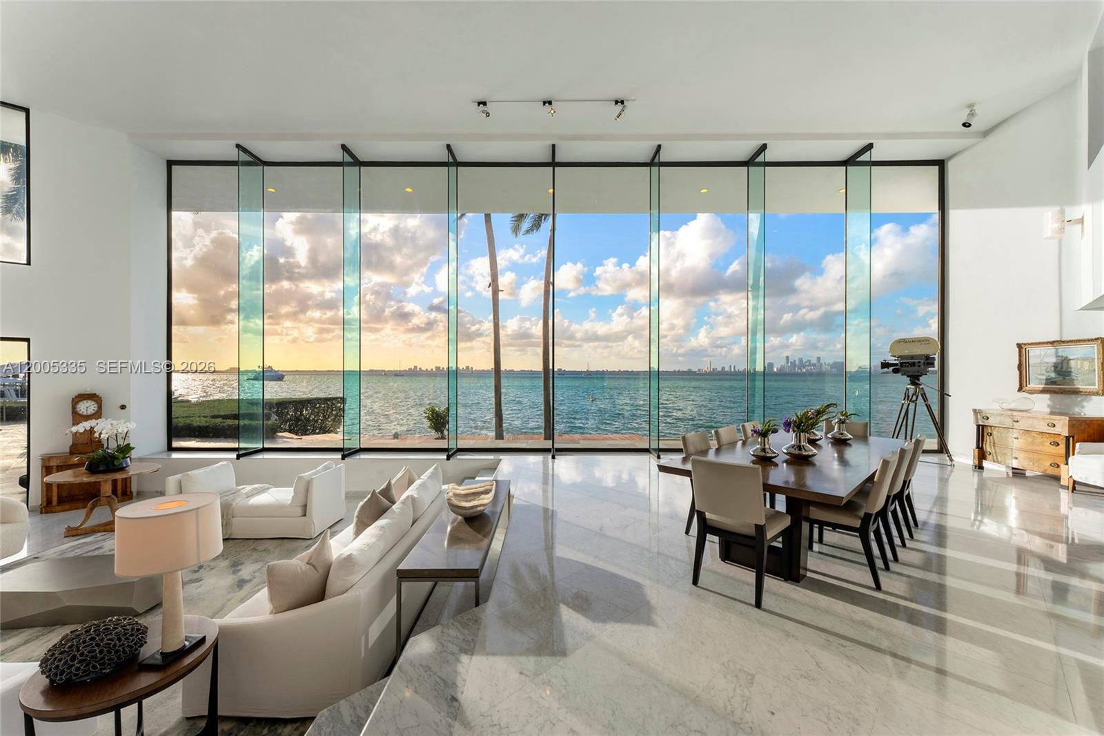 A bright living and dining area features floor-to-ceiling windows overlooking the ocean and city — 485 W Matheson Dr, Key Biscayne FL 33149, KEY BISCAYNE, FL