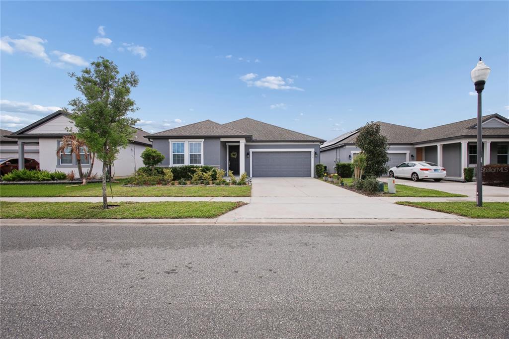 A gray single-story suburban house with a two-car garage and a paved driveway — 5732 IRON BRAND ROAD, ST CLOUD, FL