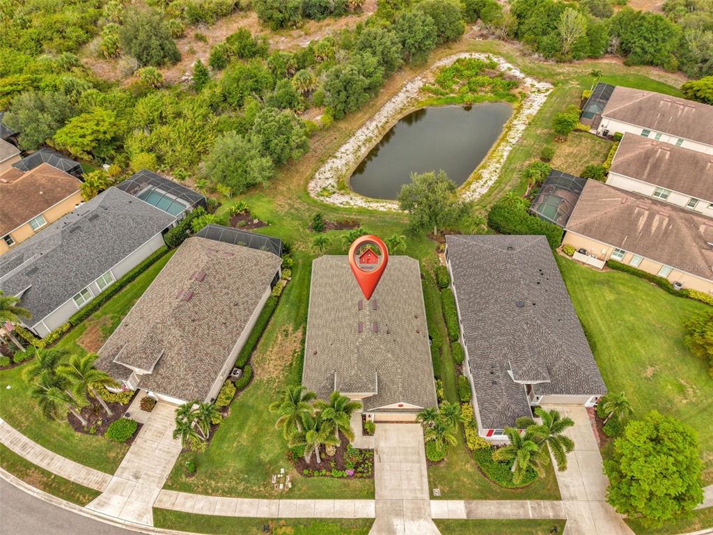 An aerial view shows a residential house with a red location pin on its roof — 2205 TERRACINA DRIVE, VENICE, FL