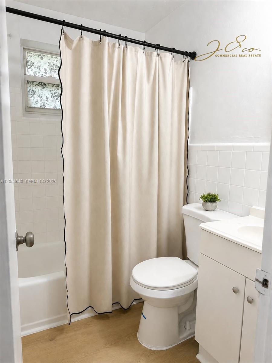 A bathroom features a beige shower curtain, a white toilet, and a white vanity cabinet — 1465 W 28th St # 4, Hialeah FL 33010, HIALEAH, FL