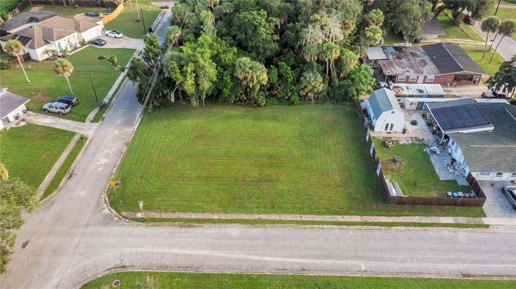 An aerial view shows a vacant, rectangular grass lot situated between two residential properties — 4005 VANGUARD AVENUE, TITUSVILLE, FL