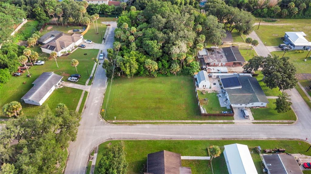 An aerial view shows a vacant rectangular lot situated between two existing residential properties — 4005 VANGUARD AVENUE, TITUSVILLE, FL