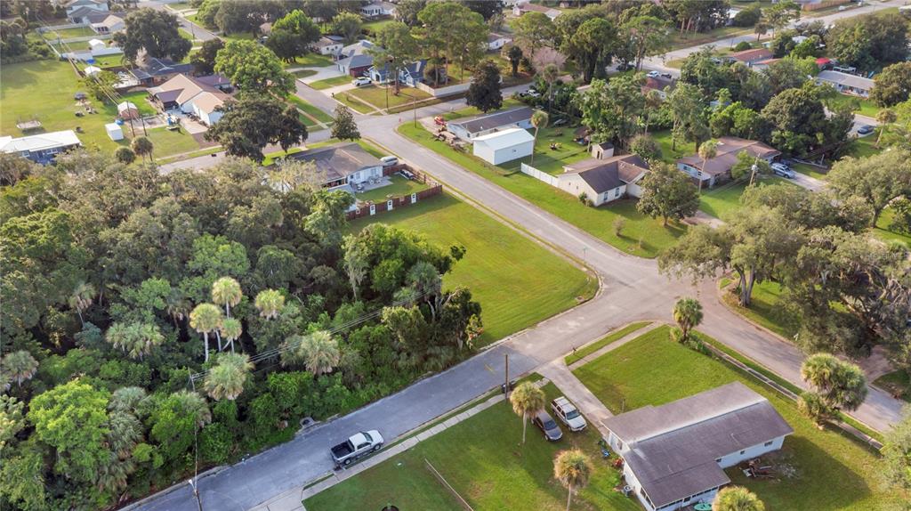 An aerial view shows a residential neighborhood with houses, streets, and a large wooded lot — 4005 VANGUARD AVENUE, TITUSVILLE, FL
