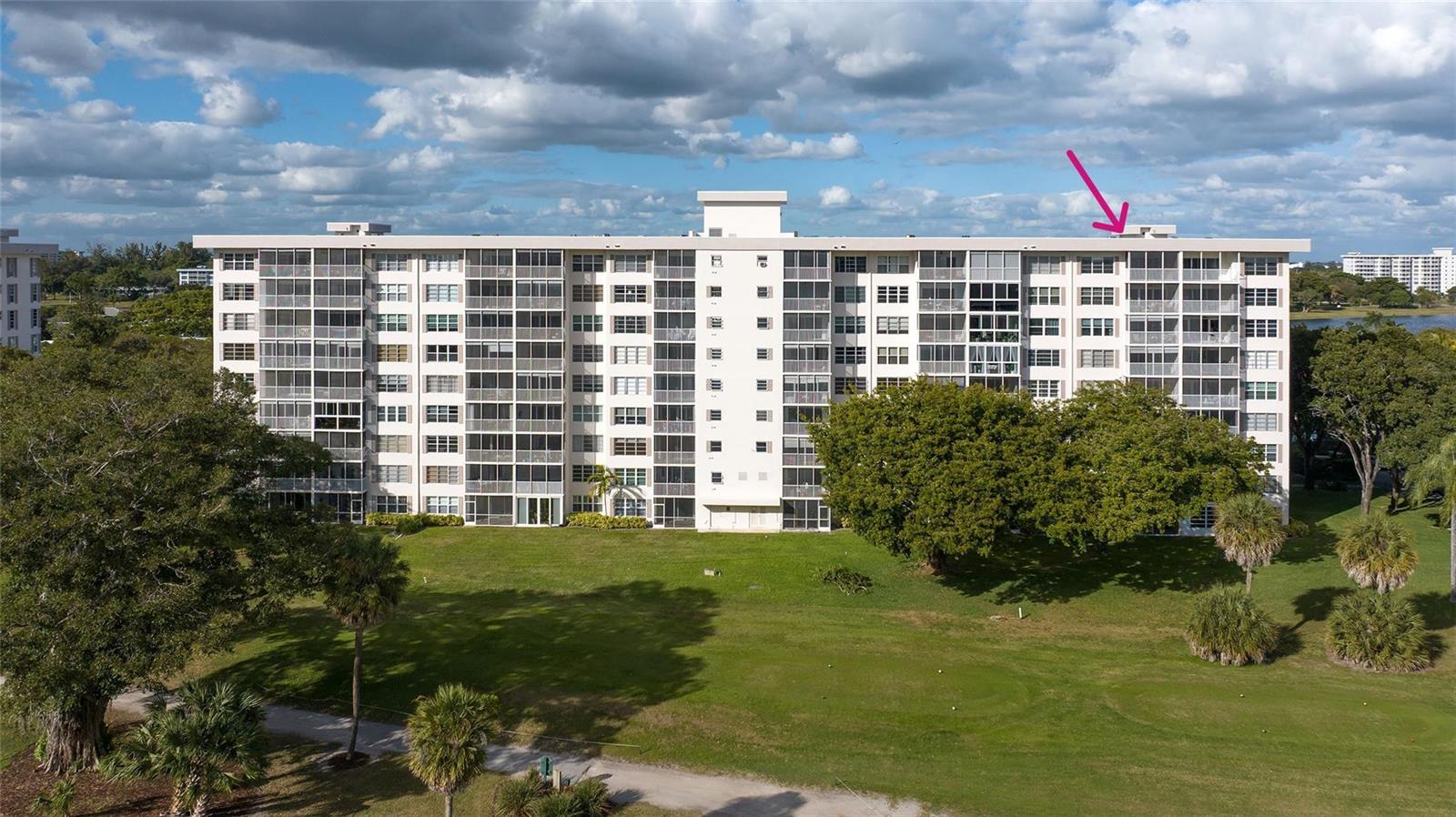 An exterior view of a multi-story apartment building overlooking a golf course — 3050 N Palm Aire Drive # 909, Pompano Beach FL 33069, POMPANO BEACH, FL