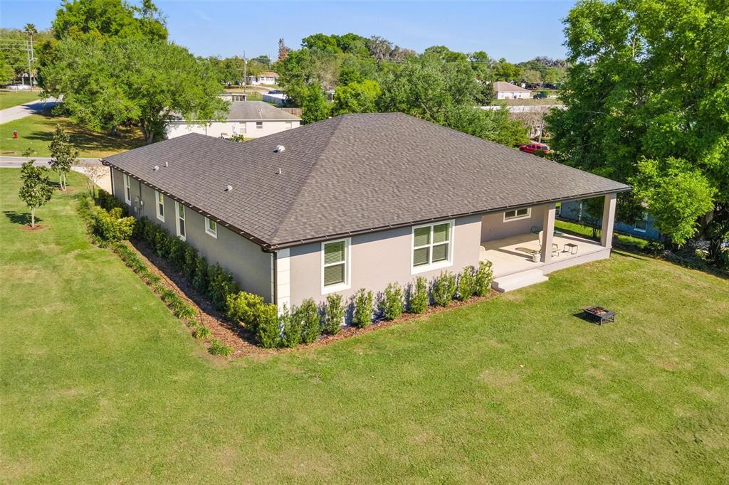 An aerial view of a single-story house with a gray roof and a covered patio — 415 N DIXIE DRIVE, HOWEY IN THE HILLS, FL