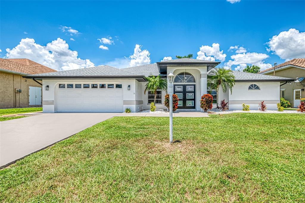 A single-story house with a white exterior, a two-car garage, and a front entryway — 3077 STONE STREET, PORT CHARLOTTE, FL