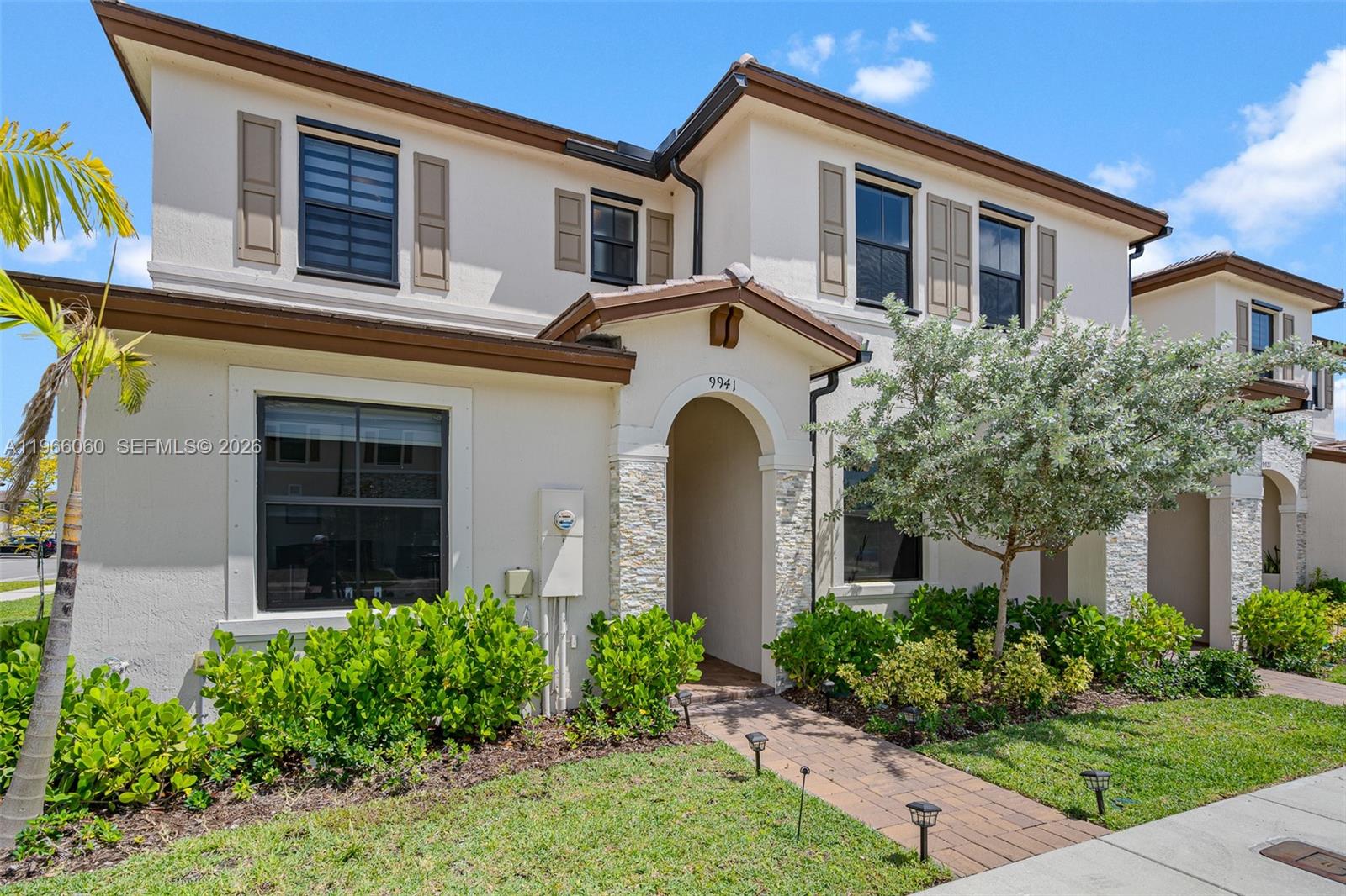 A two-story stucco house features brown trim, stone accents, and a brick walkway — 9941 SW 231st Ln # 9941, Miami FL 33190, MIAMI, FL