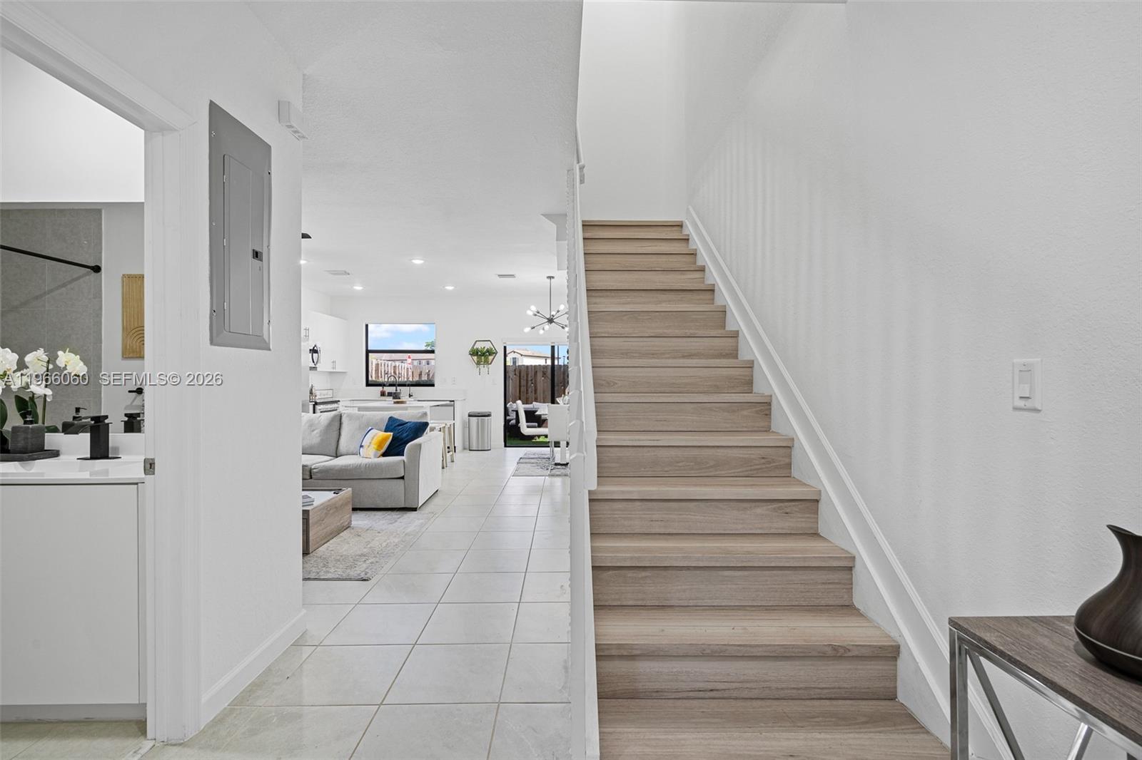A staircase with wood-look steps leads upward beside a tiled hallway and open living area — 9941 SW 231st Ln # 9941, Miami FL 33190, MIAMI, FL