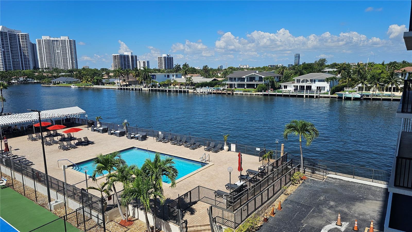 An elevated view of a swimming pool deck overlooking a canal with waterfront homes — 2017 S Ocean Dr # 408, Hallandale Beach FL 33009, HALLANDALE BEACH, FL