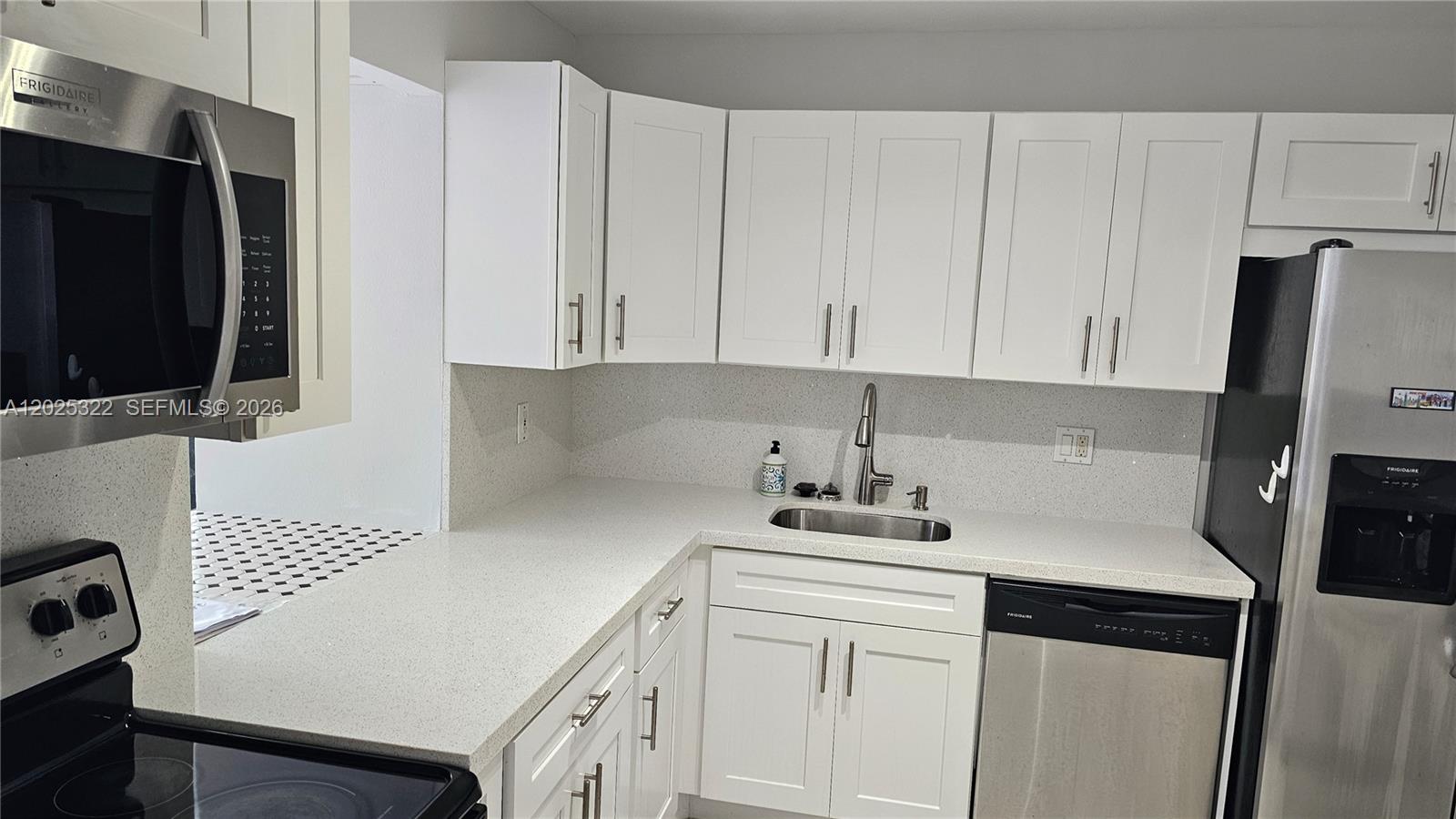 A kitchen features white cabinets, stainless steel appliances, and light-colored quartz countertops — 2017 S Ocean Dr # 408, Hallandale Beach FL 33009, HALLANDALE BEACH, FL