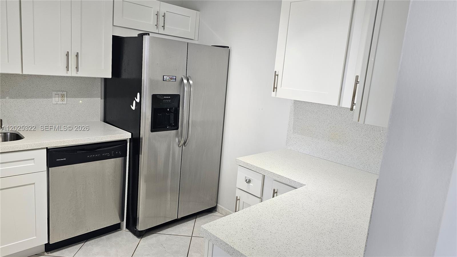 A kitchen features white cabinets, stainless steel appliances, and light-colored speckled countertops — 2017 S Ocean Dr # 408, Hallandale Beach FL 33009, HALLANDALE BEACH, FL