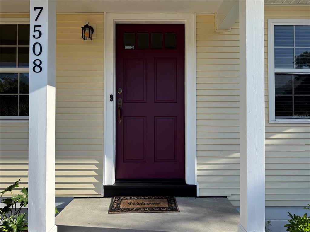 A front entrance features a maroon door, light yellow siding, and a house number post — 7508 4TH AVENUE N, ST PETERSBURG, FL