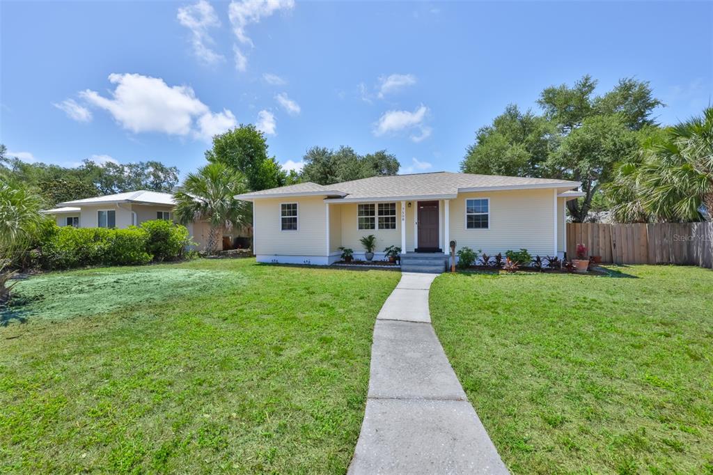 A single-story yellow house with a front walkway and lawn under a blue sky — 7508 4TH AVENUE N, ST PETERSBURG, FL