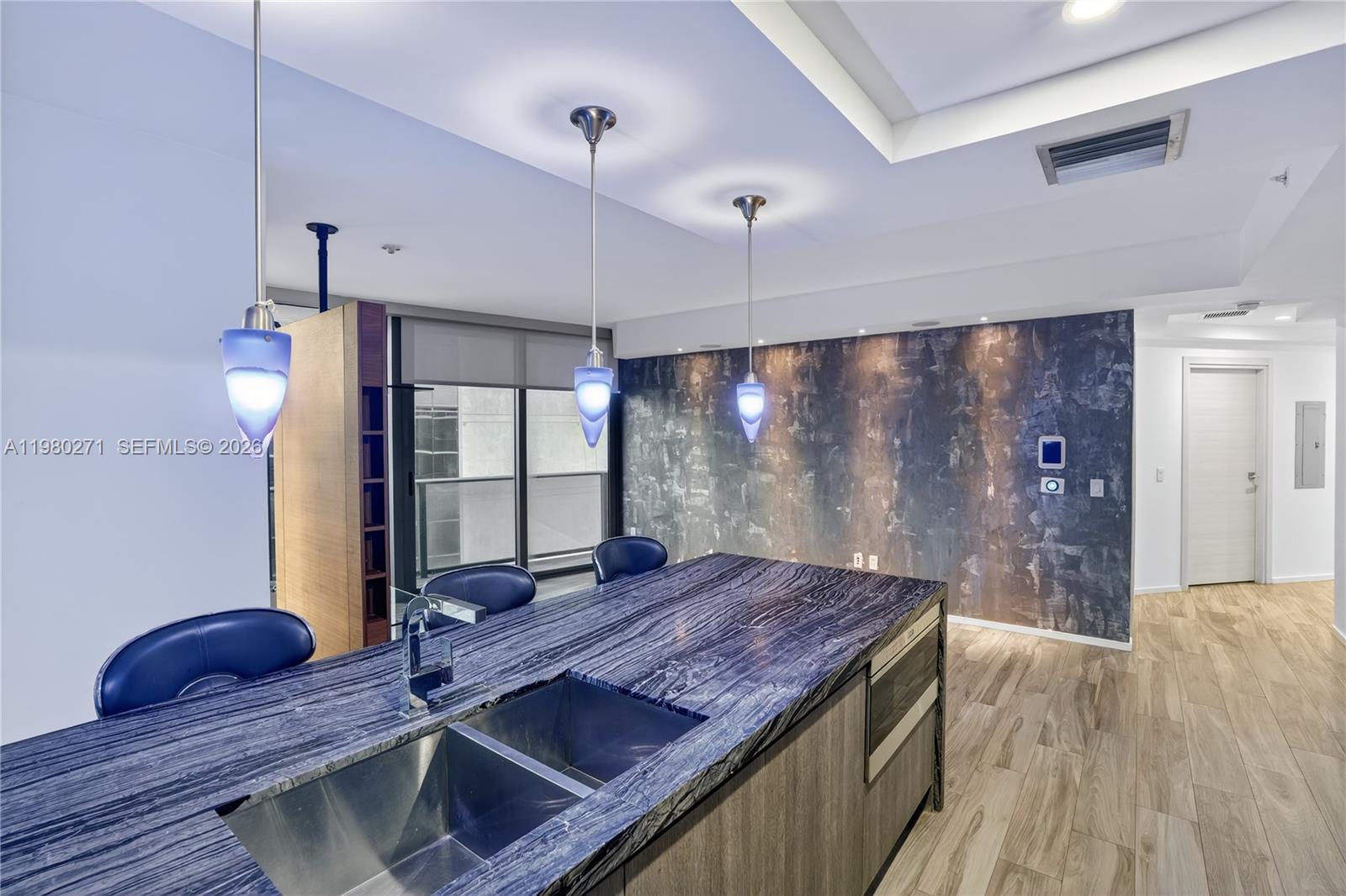 A kitchen island with a blue stone countertop and sink sits before a textured wall — 801 S Miami Ave # 2805, Miami FL 33130, MIAMI, FL