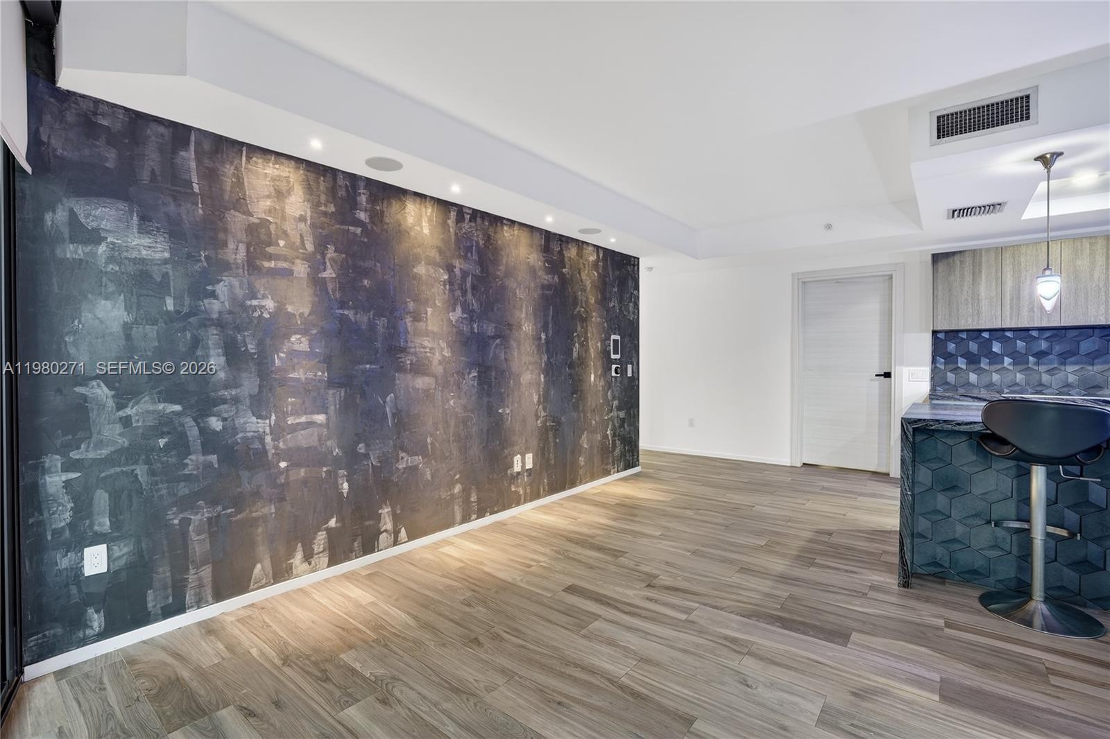 A room features a dark textured accent wall, wood-look flooring, and a kitchen island — 801 S Miami Ave # 2805, Miami FL 33130, MIAMI, FL