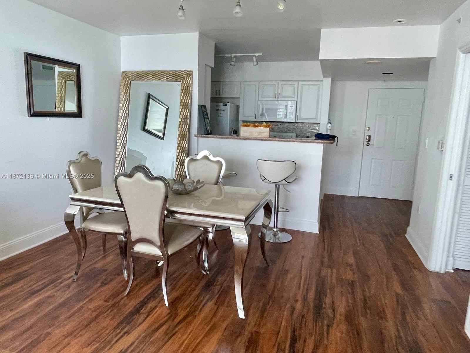 A dining area with a metallic table and chairs sits adjacent to a kitchen counter — 1155 Brickell Bay Dr # 1805, Miami FL 33131, MIAMI, FL