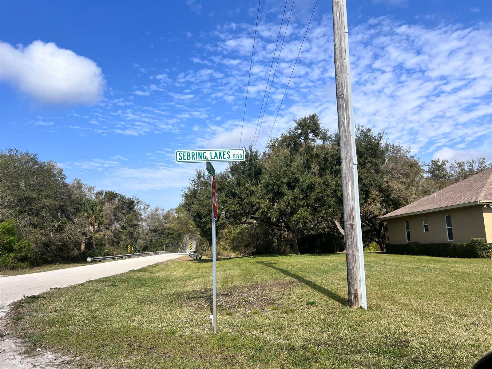 A street sign for Sebring Lakes Blvd stands near a road, utility pole, and house — 4108 Sebring Lakes Boulevard, FL 33875, FL