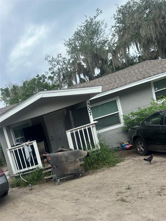 A gray house with a front porch, a shopping cart, and a parked car — 307 AVENUE X NE, WINTER HAVEN, FL