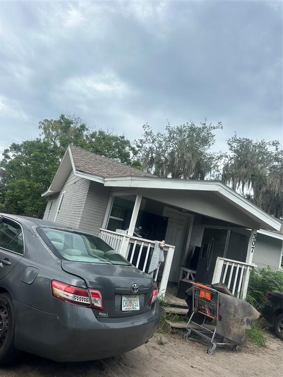 A gray house with a front porch, a parked car, and a shopping cart outside — 307 AVENUE X NE, WINTER HAVEN, FL