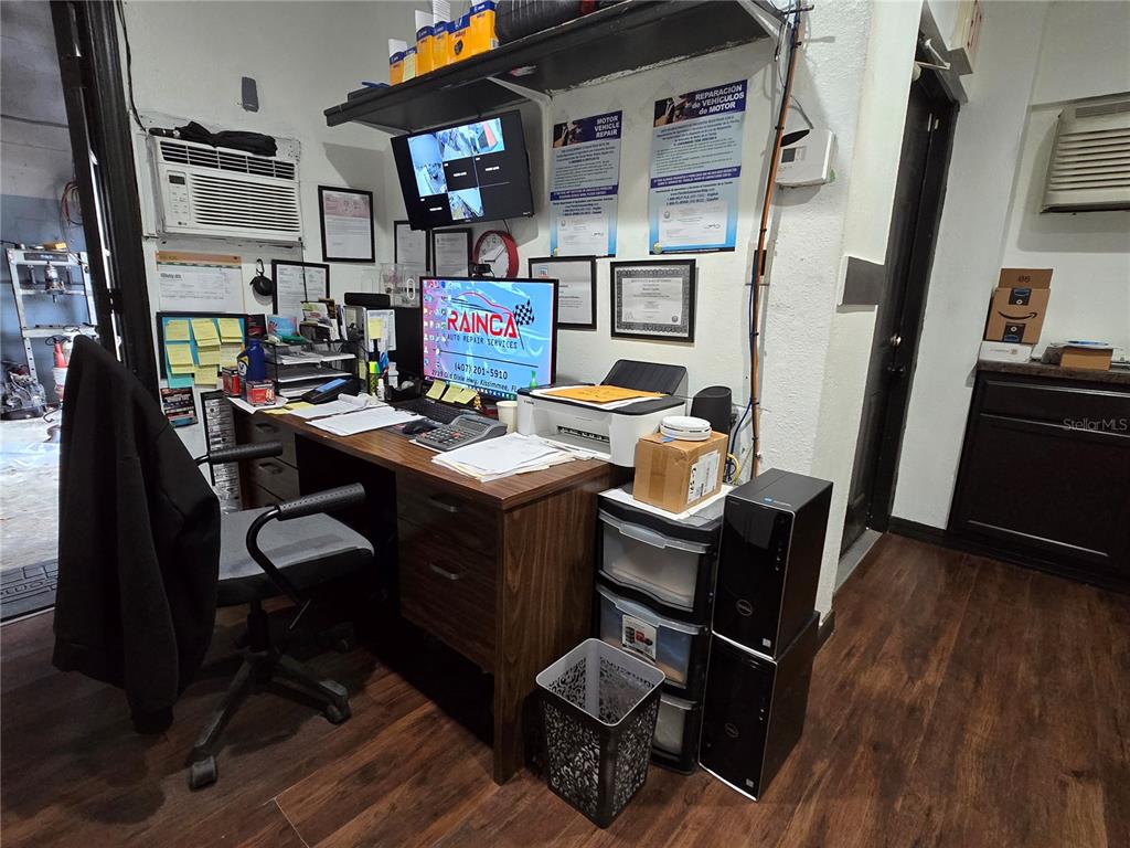 A small office space features a wooden desk, computer equipment, and various wall-mounted business documents — 2719 OLD DIXIE HWY, KISSIMMEE, FL