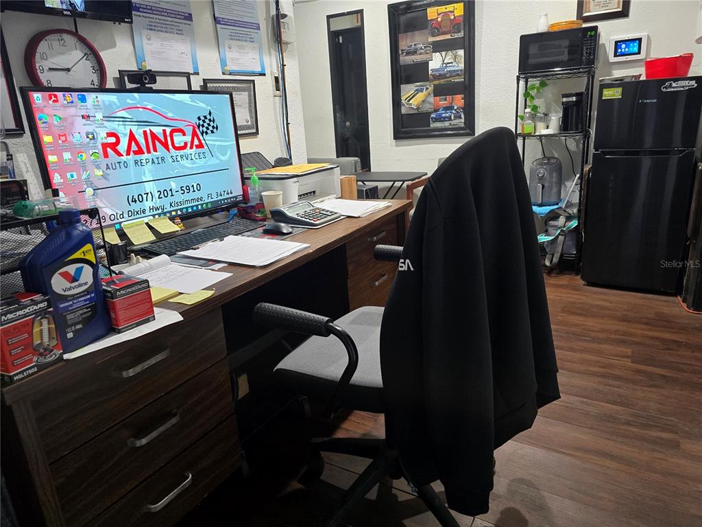 A desk with a computer monitor, office chair, and various supplies sits in an office — 2719 OLD DIXIE HWY, KISSIMMEE, FL