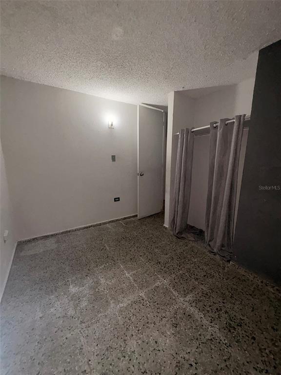 A small bedroom with gray walls, a textured ceiling, and speckled tile flooring — Calle Geminis 13, CANOVANAS, PR