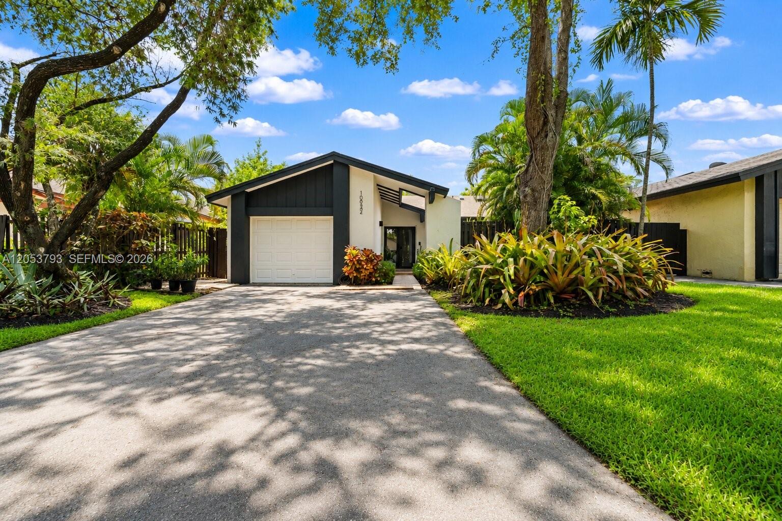 A single-story house with a garage, driveway, and landscaping under a blue sky — 10932 SW 135th Ct Cir, Miami FL 33186, MIAMI, FL