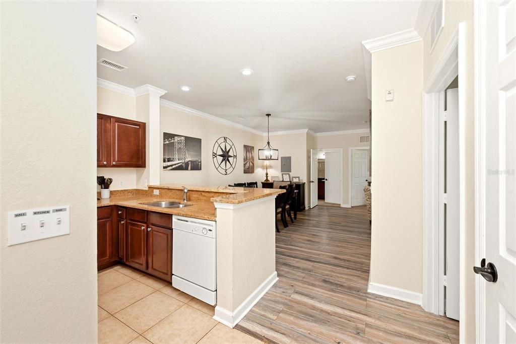 A kitchen with dark wood cabinets and a breakfast bar overlooks a dining area — 1301 TUSCAN TERRACE UNIT 9406, DAVENPORT, FL