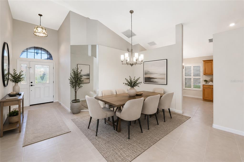 A dining room with a wooden table and chairs sits near an entryway with tile — 5133 FLAGSTONE DRIVE, SARASOTA, FL
