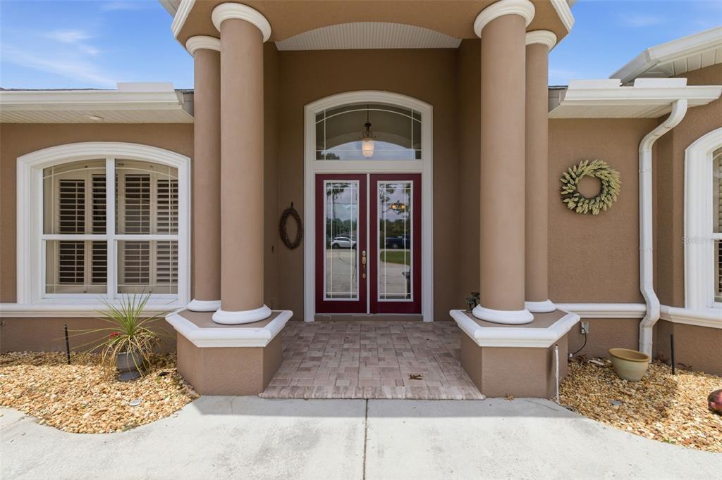 The front entrance of a house features two columns, a double door, and a window — 11145 MOUNTAIN MOCKINGBIRD RD, WEEKI WACHEE, FL