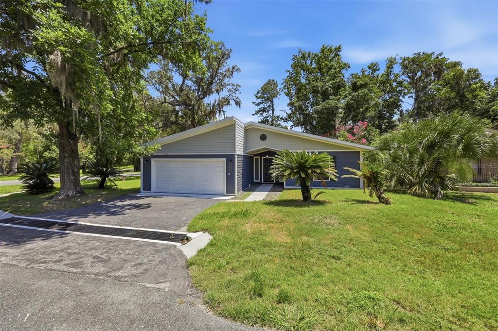 A single-story house with a blue and gray exterior, a garage, and a front lawn — 6840 NW 111TH LANE, ALACHUA, FL