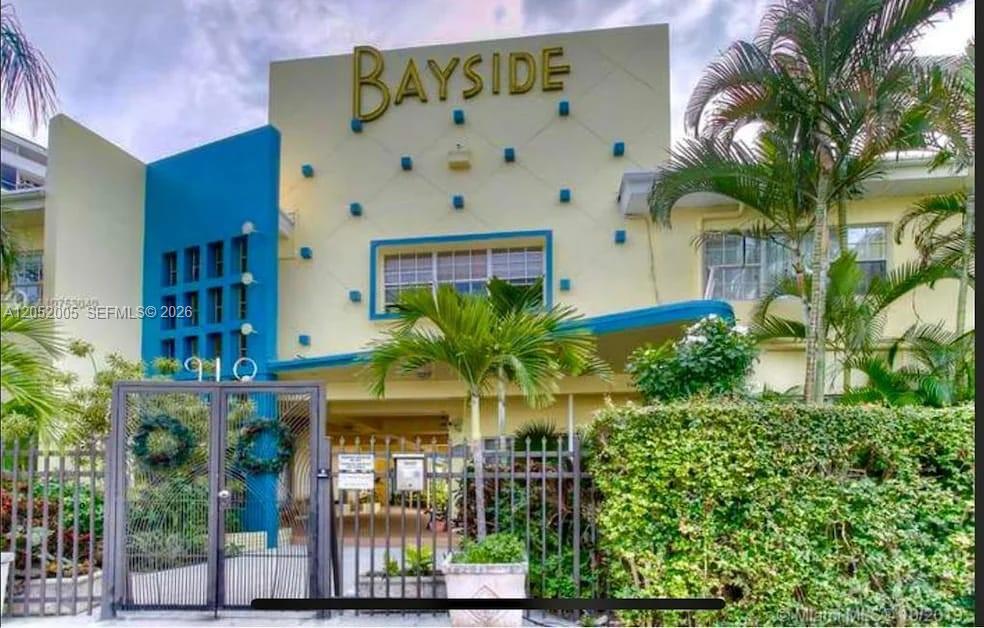 The exterior of a multi-story apartment building features a yellow facade with blue accents — 910 Bay Dr # 9, Miami Beach FL 33141, MIAMI BEACH, FL