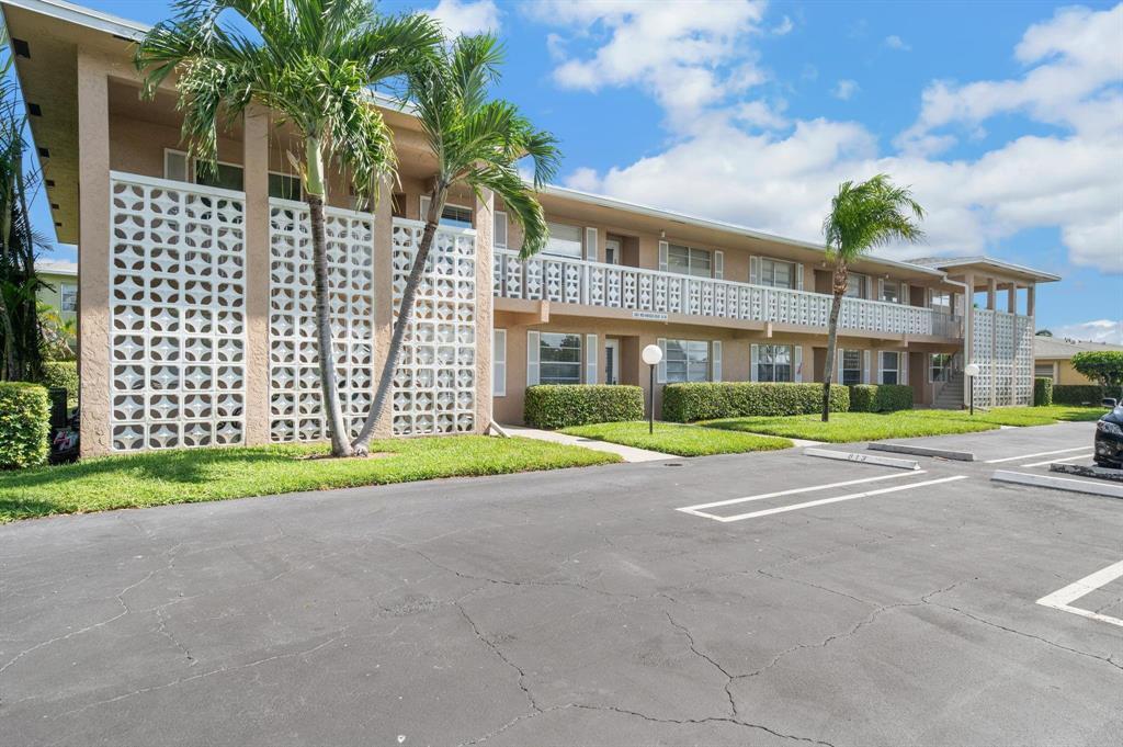A two-story apartment building features decorative concrete block screens and a paved parking lot — 2601 Red Hibiscus Boulevard, Delray Beach FL 33445, DELRAY BEACH, FL