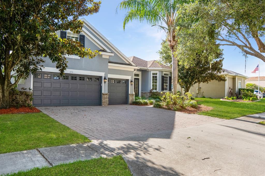 A gray single-story house with a two-car garage and a paved driveway — 1771 LEE JANZEN DRIVE, KISSIMMEE, FL