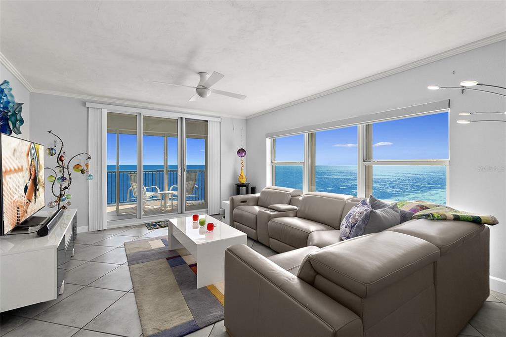 A living room with a gray sectional sofa, white coffee table, and ocean views — 3425 S ATLANTIC AVENUE UNIT 1206, DAYTONA BEACH SHORES, FL