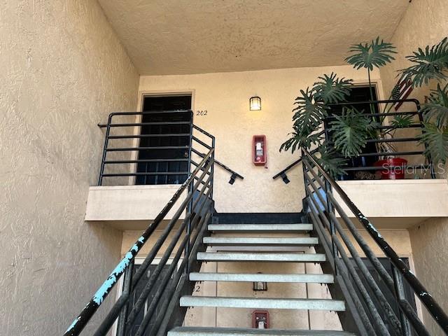 An exterior view of a staircase leading to an apartment entrance with a potted plant — 670 SANDY NECK LANE UNIT 202, ALTAMONTE SPRINGS, FL