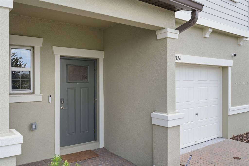 The exterior view shows a gray front door and a white garage door — 9124 GALLANTREE PLACE, LAND O LAKES, FL