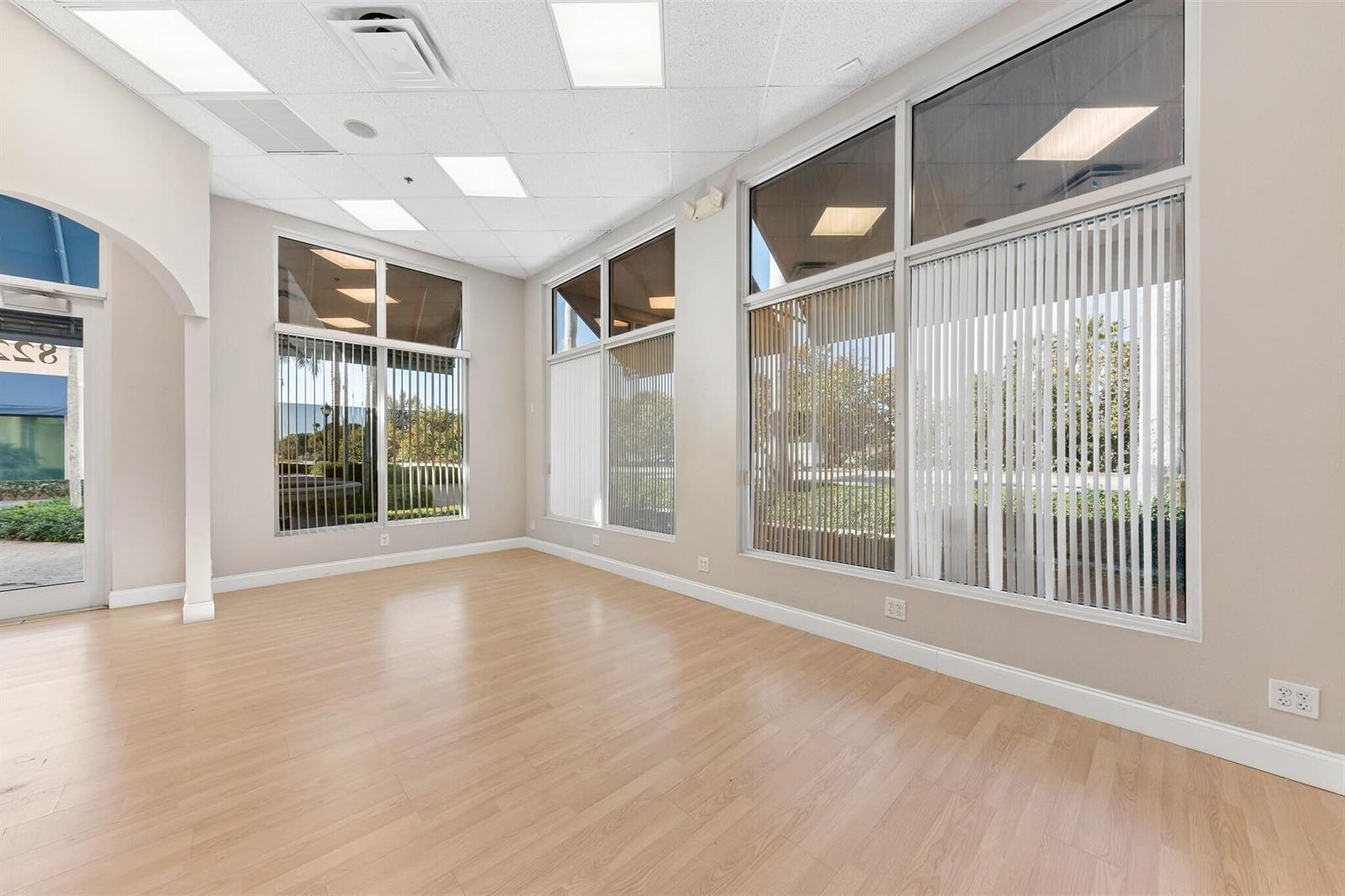 An empty commercial space features light wood flooring, tall windows with vertical blinds, and recessed lighting — 826 N Dixie Highway # 15, Lantana FL 33462, LANTANA, FL