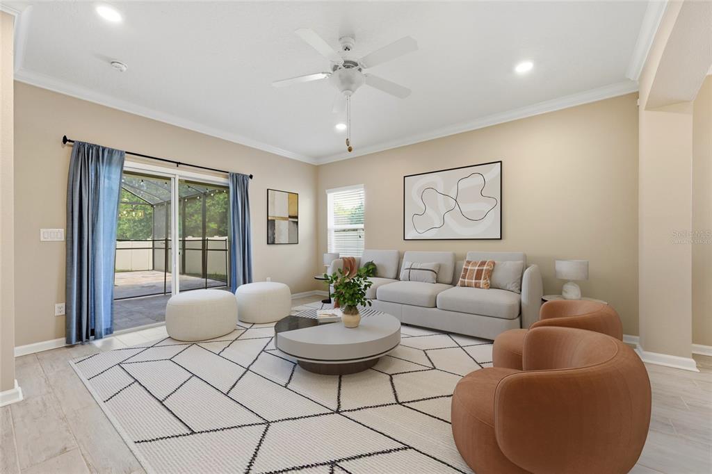A living room features a light gray sofa, two orange armchairs, and a geometric rug — 2408 LAS CALINAS BOULEVARD, ST AUGUSTINE, FL