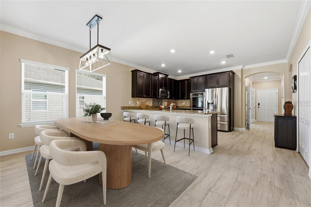A dining area with a wooden table and chairs sits adjacent to a modern kitchen — 2408 LAS CALINAS BOULEVARD, ST AUGUSTINE, FL