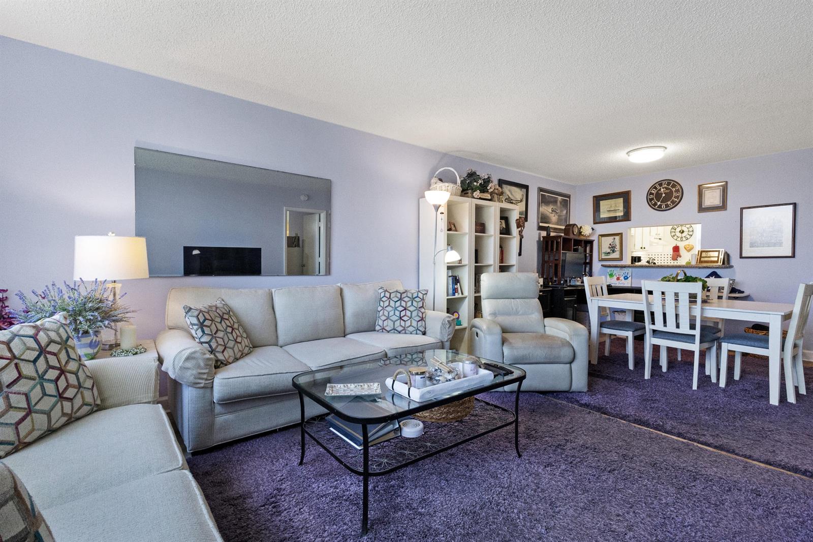A living room features a light-colored sofa, a glass coffee table, and purple carpeting — 6870 Royal Palm Boulevard # 202m, Margate FL 33063, MARGATE, FL