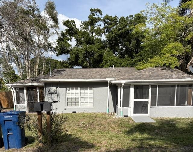 A single-story gray house with a screened-in porch and a blue trash bin outside — 5719 14TH STREET E, BRADENTON, FL