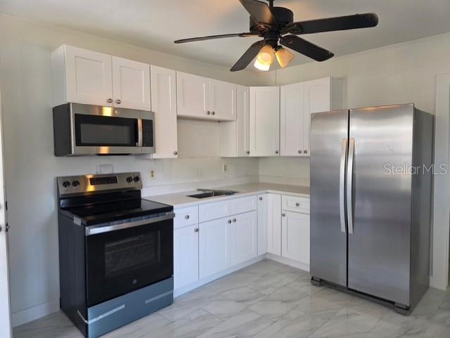 A kitchen with white cabinets, stainless steel appliances, and light-colored tile flooring — 5719 14TH STREET E, BRADENTON, FL