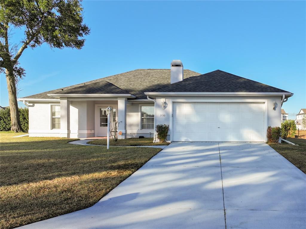 A single-story house with a white stucco exterior, a two-car garage, and a shingled roof — 3150 NW 50TH COURT, OCALA, FL