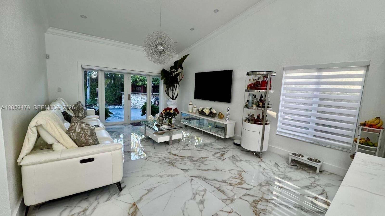 A living room features white leather furniture, marble flooring, a television, and a glass bar — 11500 SW 153rd Ave # 1, Miami FL 33196, MIAMI, FL