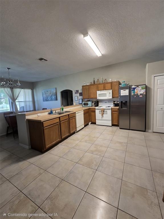 A kitchen with wood cabinets, stainless steel appliances, and tile flooring — 407 MARTIGUES DRIVE, KISSIMMEE, FL