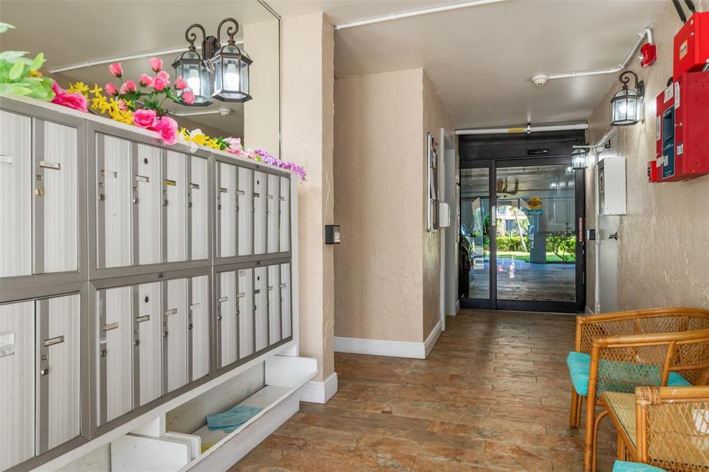 A building lobby features a wall of metal mailboxes, tile flooring, and a glass entrance — 25188 MARION AVENUE UNIT A108, PUNTA GORDA, FL