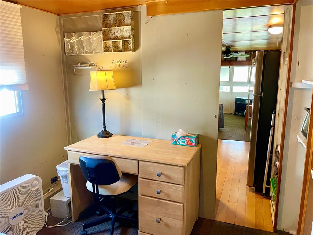 A home office features a wooden desk, a chair, a lamp, and a doorway leading elsewhere — 13 TENNESSEE STREET, PALMETTO, FL